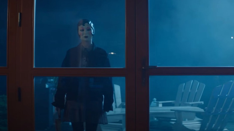 Doll Face looking into a cabin window (2025)