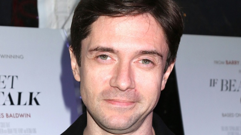 Topher Grace smirking