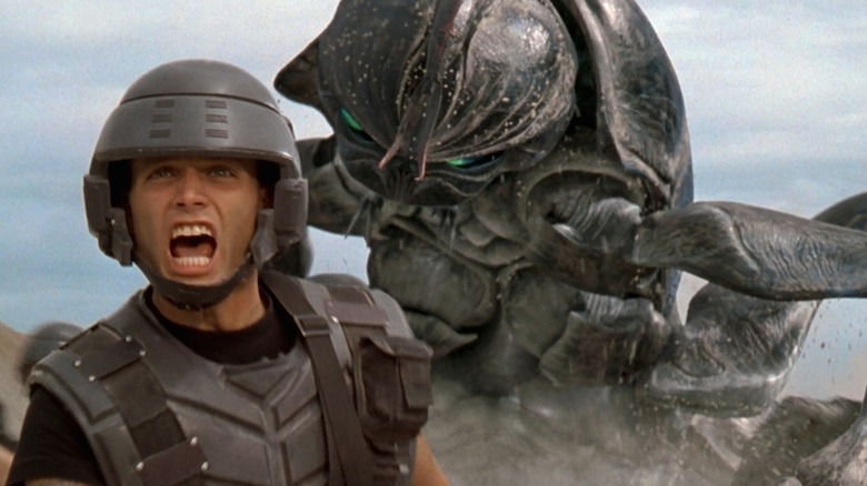 Johnny Rico yelling with a tank bug behind him in "Starship Troopers" (1997)