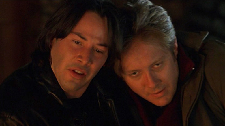 Keanu Reeves and James Spader leaning together
