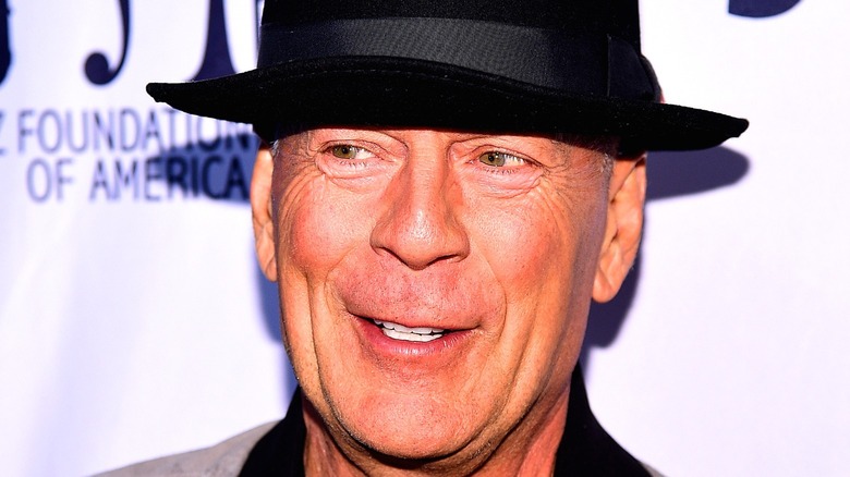 Bruce Willis wearing a black hat