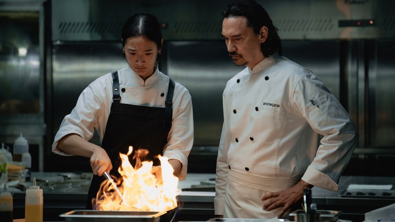 Aoy and Chef Paul cooking over open flame