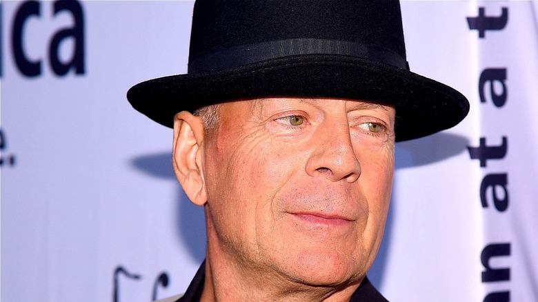 Bruce Willis wearing a black hat 