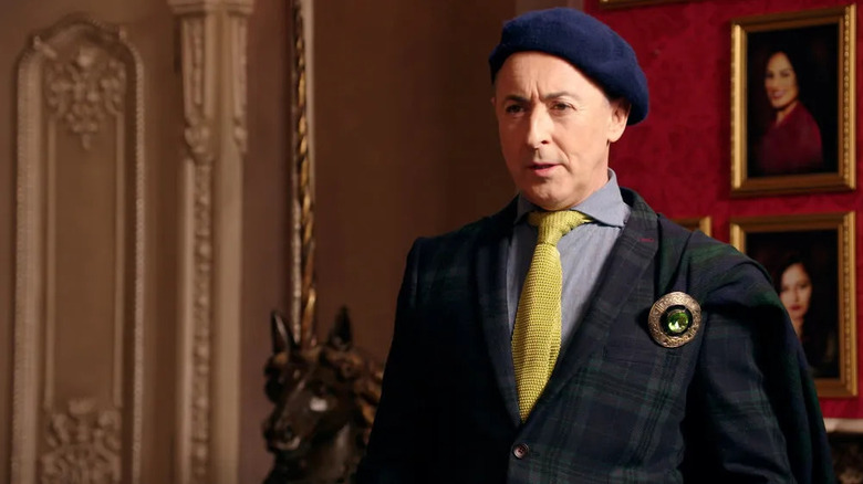 Alan Cumming hosting The Traitors in a beret
