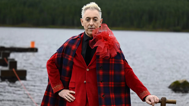 Alan Cumming poses in red on 