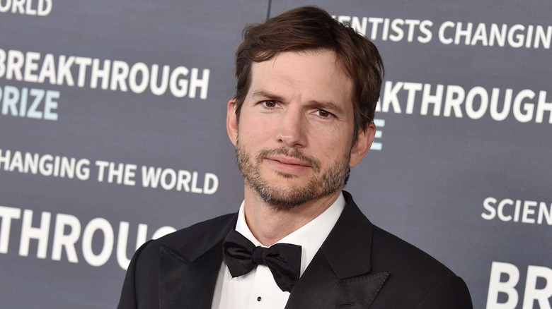 Kutcher posing in tux at an event