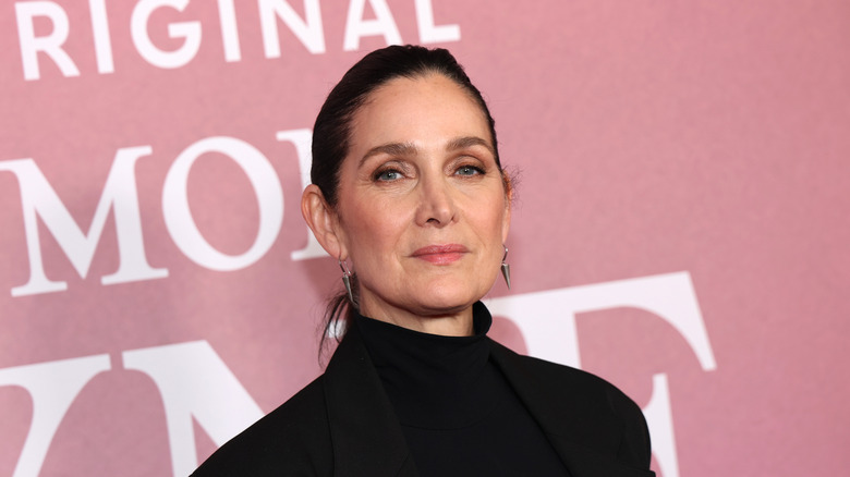 Carrie-Anne Moss with short hair and earrings