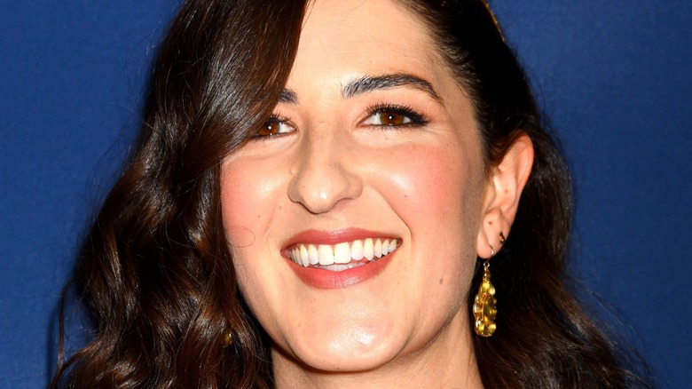 D'Arcy Carden smiling blue background