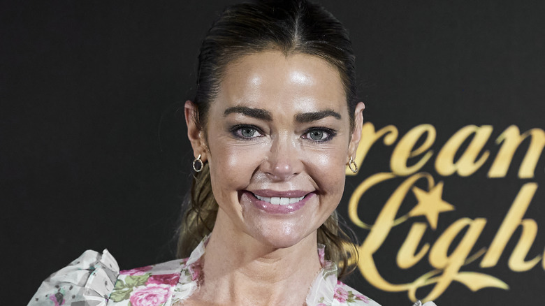 Denise Richards smiling in floral dress