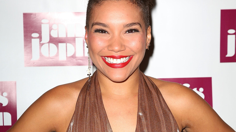 Emmy Raver-Lampman smiling with red lipstick