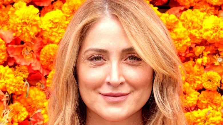 Sasha Alexander in front of a bunch of flowers