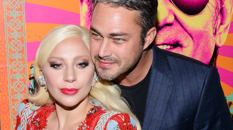 Taylor Kinney leaning into Lady Gaga