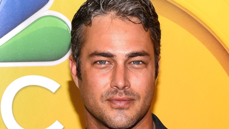 Taylor Kinney in front of yellow background