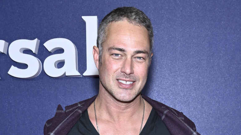 Taylor Kinney in front of yellow background