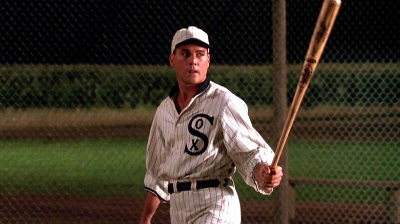Shoeless Joe Jackson stands on a baseball field while holding a baseball bat in Field of Dreams