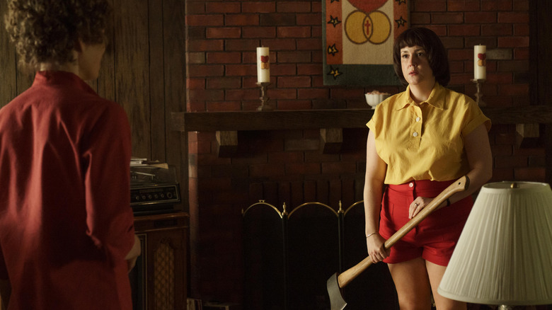 Betty Gore holding an axe looking at Candy