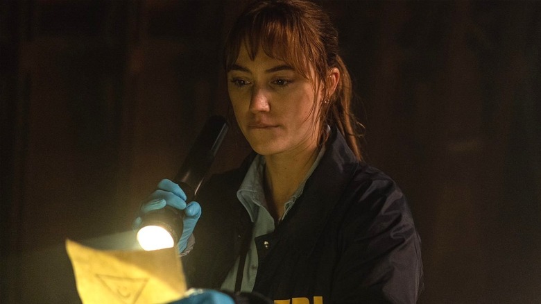 Lee pointing flashlight at document