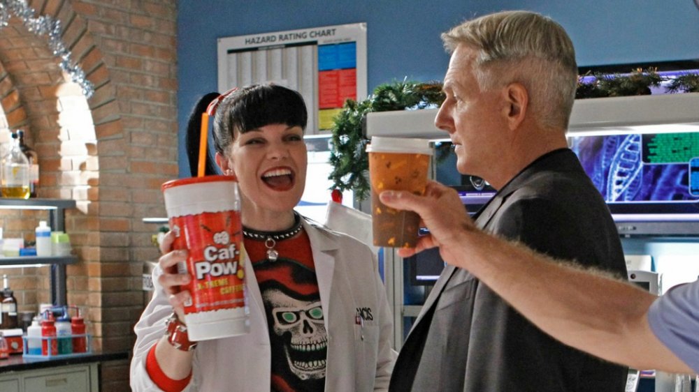 Pauley Perrette as Abby Sciuto gleefully holds a cup of Caf-Pow while Mark Harmon as Leroy Jethro Gibbs looks fed up in NCIS