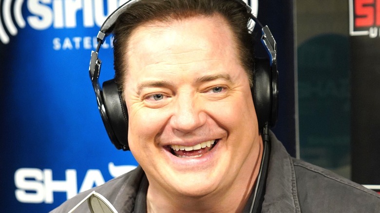 Brendan Fraser smiling and wearing headphones