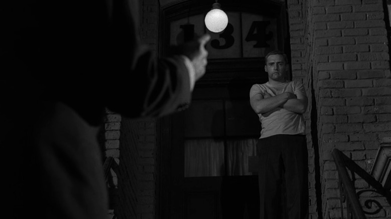 Peter Vollmer standing atop a stoop and watching Adolf Hitler speak with his finger pointed