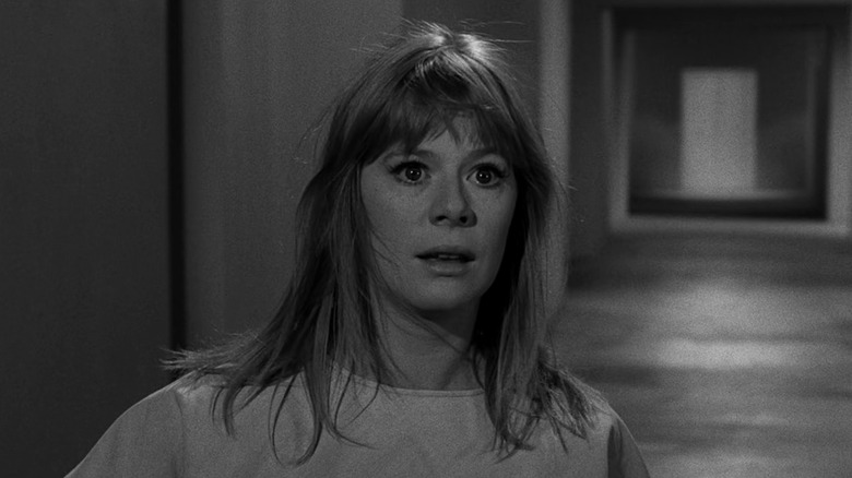 Marilyn Cuberle standing in shock in the middle of a corridor