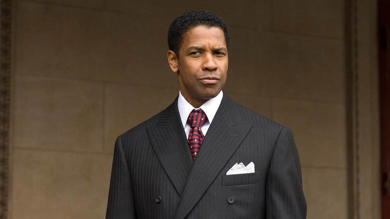 Frank Lucas smiling slightly wearing a suit with a red and blue tie