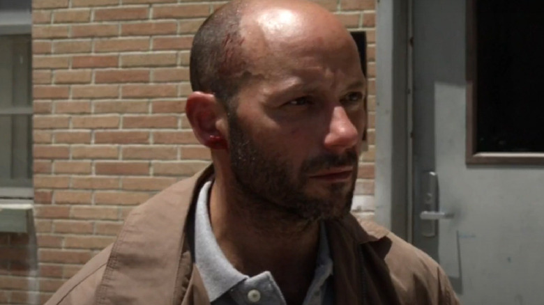 Chucky Face stands in front of a brick wall in 