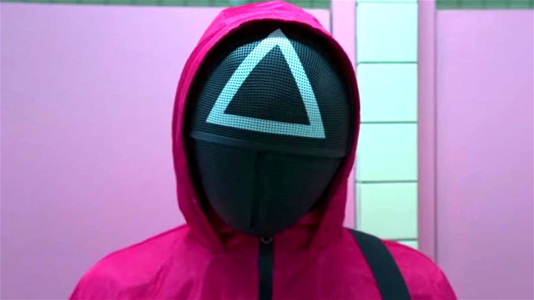 Squid Game guard wearing triangle mask