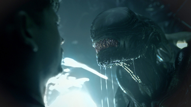 Xenomorph drooling as it faces down its human prey