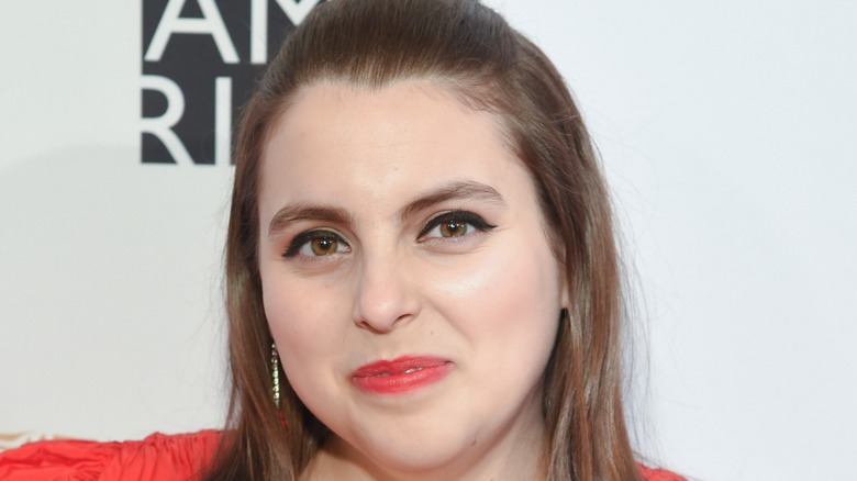 Beanie Feldstein smiling on red carpet