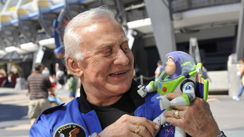 Buzz Aldrin poses with a Buzz Lightyear toy