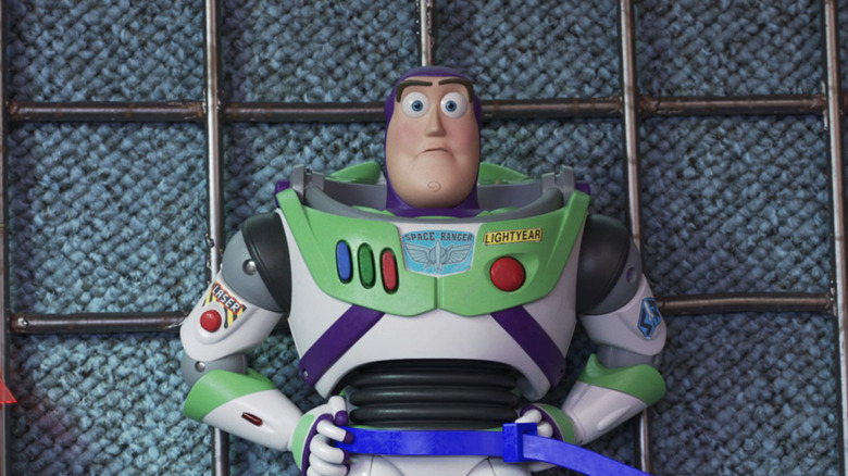 Buzz is zip-tied to a carnival game wall