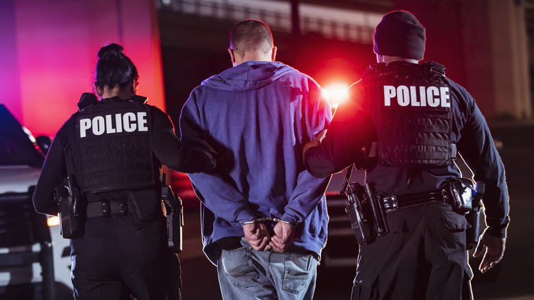 Police arresting man in hoodie