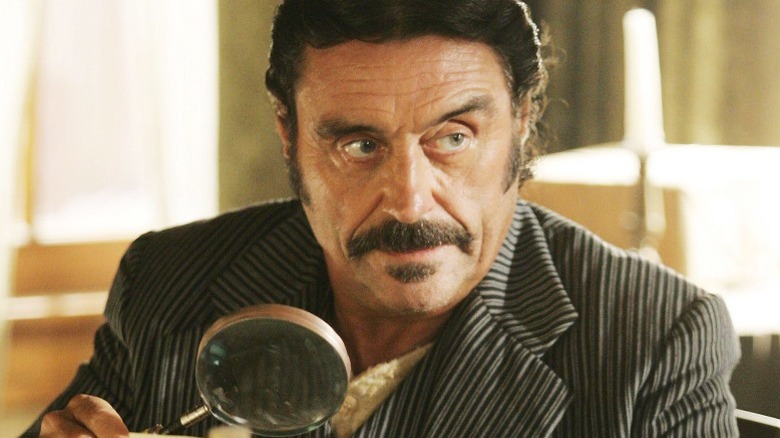 Al Swearengen holding magnifying glass