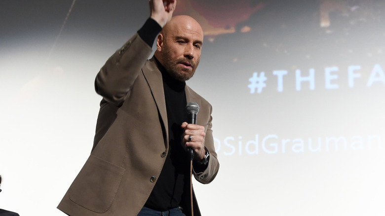 a bald John Travolta dancing