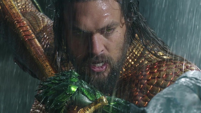 Aquaman holding his trident in the rain