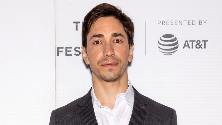 Justin Long wearing grey suit
