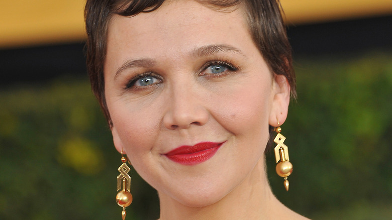 Maggie Gyllenhaal smiling with red lipstick