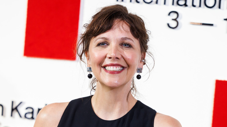 Maggie Gyllenhaal smiling with red lipstick