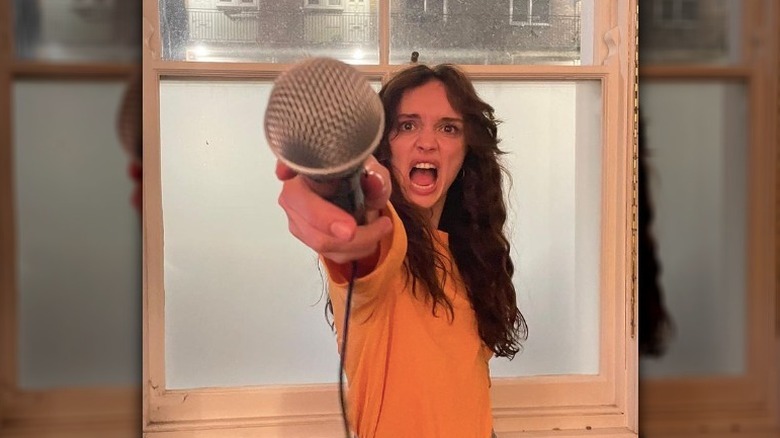 Olivia holding out a microphone