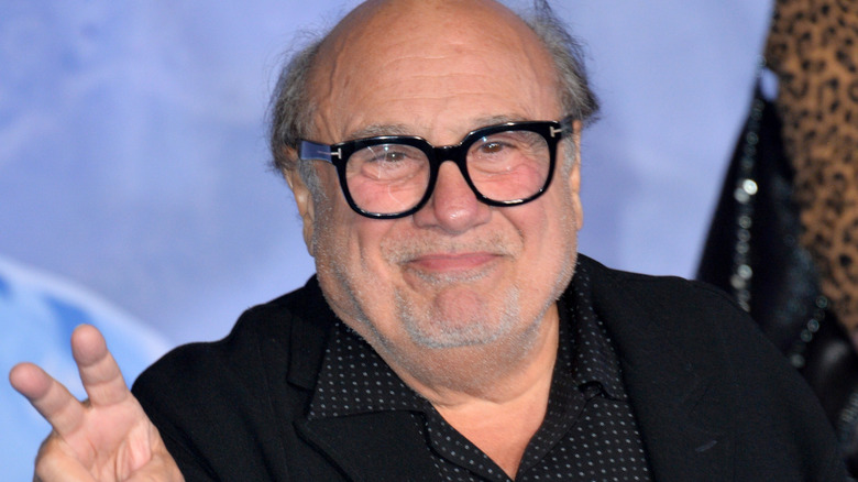 Danny DeVito holding up peace sign
