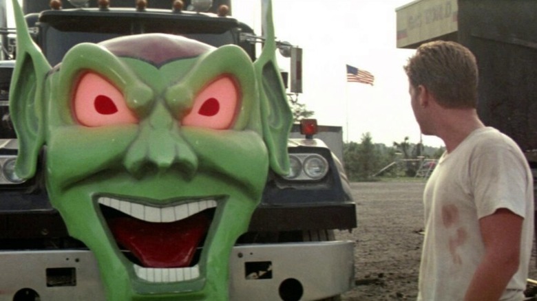 Man stood in front of truck with green face on it