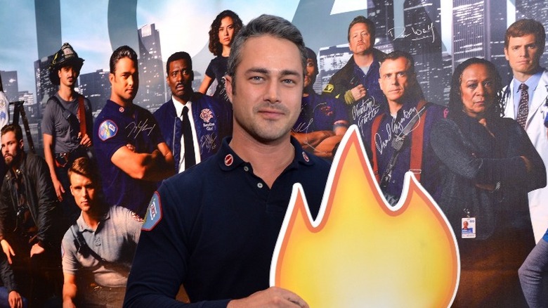 Taylor Kinney posing with fake flame 