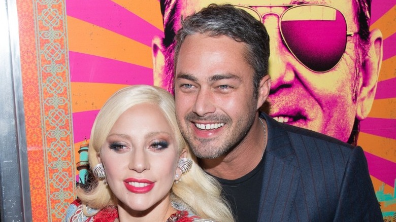 Taylor Kinney and Lady Gaga hugging and smiling