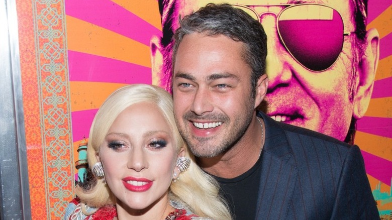 Taylor Kinney and Lady Gaga hugging and smiling