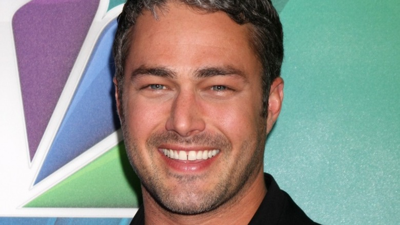 Taylor Kinney smiling at press event