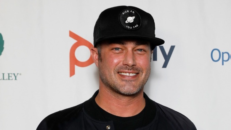 Taylor Kinney wearing baseball hat