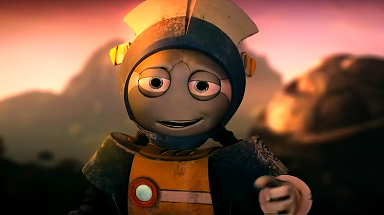 TOM 4 gestures toward the viewer