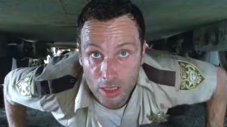 Rick crawling under a tank