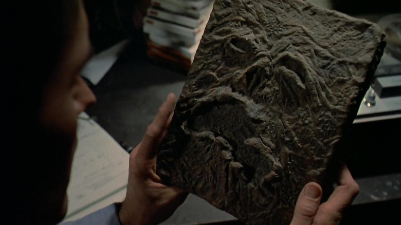 Ash holding the Necronomicon in his hands in Evil Dead 2